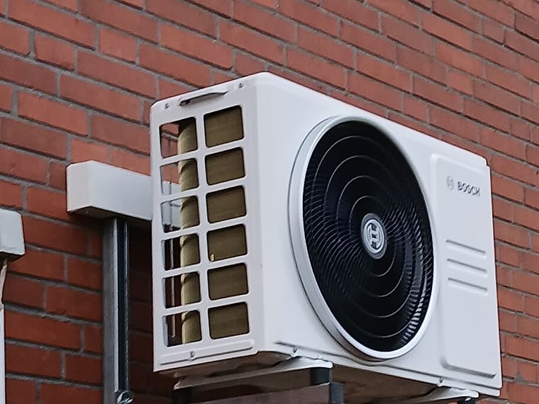 Außengerät auf Wandkonsolen an einer Klinkerfassade, erhöht montiert