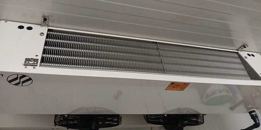 Deckenluftkühler mit zwei Ventilatoren in einer Kühlzelle mit weißer Paneelverkleidung